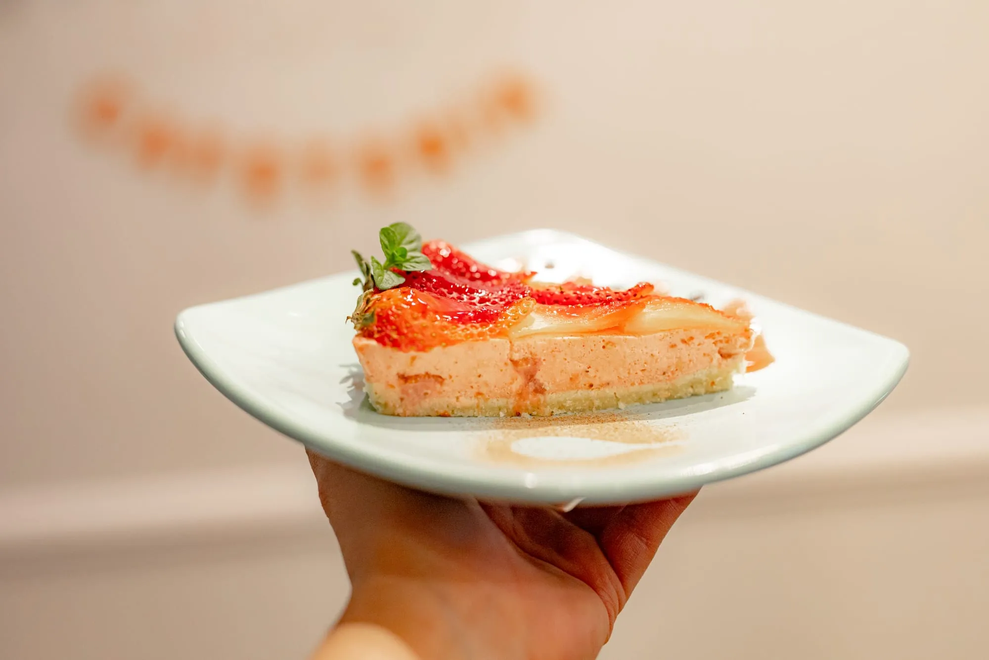 Cheesecake de frutilla frente al letrero de Tamarinda en Quito