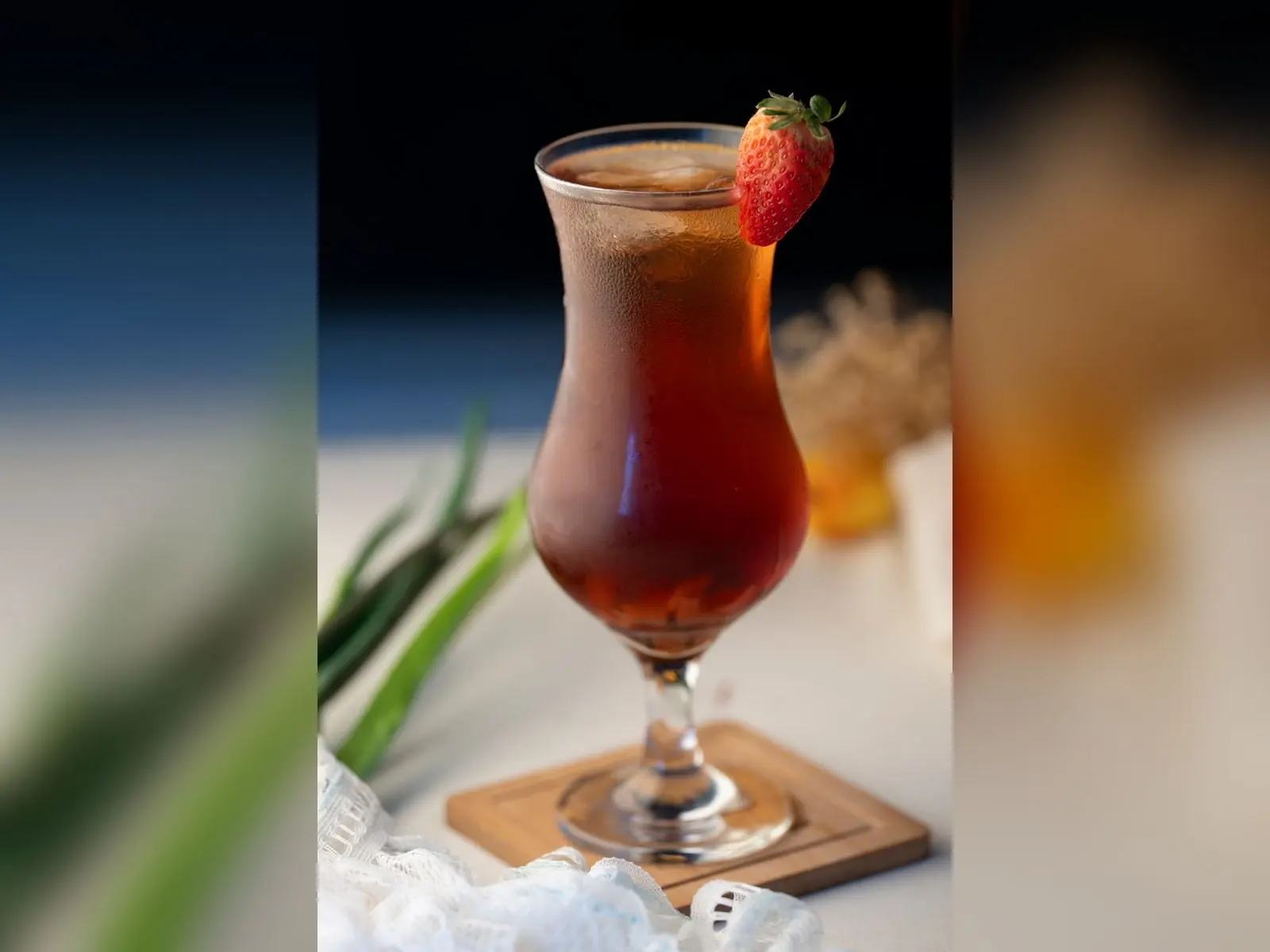 Iced tea de la casa servido en copa alta con fresa, bebida fría y frutal en La Carolina, Quito
